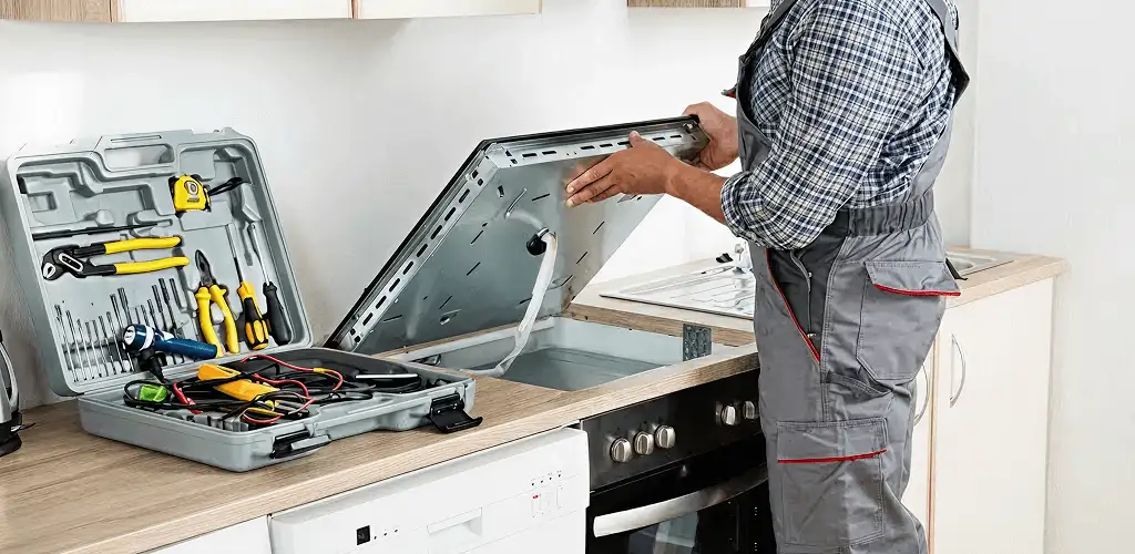 Handyman repairing a cooktop and checking wiring connections in San Jose, CA