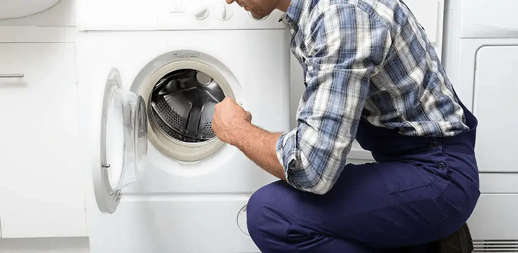 Handyman inspecting a dryer drum and internal parts for repair in San Jose, CA