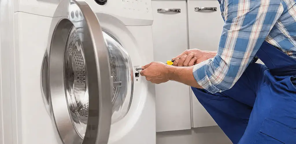 Handyman repairing a clothes dryer and checking electrical connections in San Jose, CA
