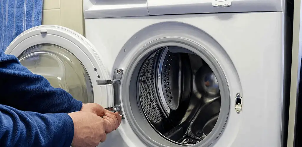 Washing machine repair handyman checking a front-load washer door and latch in San Jose, CA