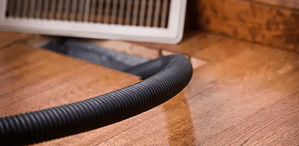 Air duct cleaning hose inserted into a floor vent for ductwork cleaning in San Jose, CA