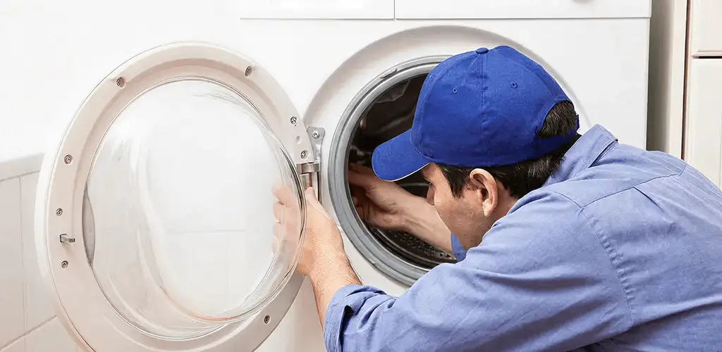 Washing machine repair handyman inspecting a front-load washer drum in San Jose, CA